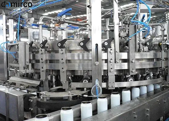 خط تولید نوشابه با دستگاه‌های پرکن و بسته‌بندی مدرن و بطری‌های آماده در حال حرکت روی نوار نقاله.