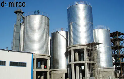 "سیلو سیمان صنعتی با تجهیزات جانبی و کارگران در حال بررسی