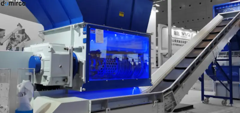 دستگاه بازیافت سیم کوچک در حال کار در یک کارگاه صنعتی، سیم‌های مسی و پلاستیک جدا شده در کنار دستگاه قابل مشاهده هستند.