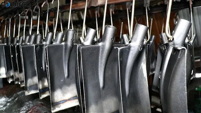 دستگاه تولید بیل دستی، متشکل از بخش برش ورق فلزی و دو واحد پرس هیدرولیک، در یک کارگاه کوچک با رعایت اصول ایمنی.