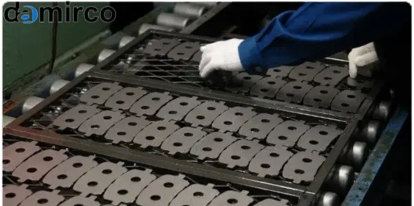 نمای کلی از خط تولید مدرن لنت ترمز در یک کارخانه، با ماشین‌آلات پیشرفته و کارکنانی که در حال نظارت بر فرآیند تولید هستند.