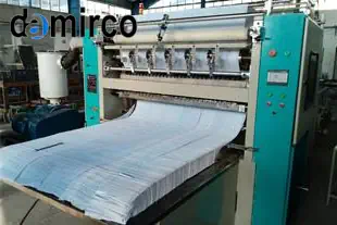 دستگاه‌های خط تولید پوشک صنعتی در حال کار در یک کارخانه مدرن، شامل واحدهای تغذیه، مونتاژ، و بسته‌بندی.