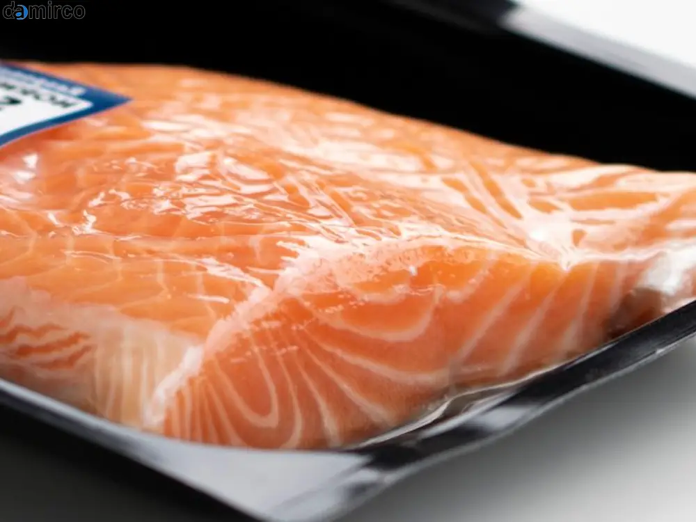 یک دستگاه اسکین پک صنعتی در حال کار در یک کارخانه و بسته‌بندی محصولات روی کارت‌های مقوایی