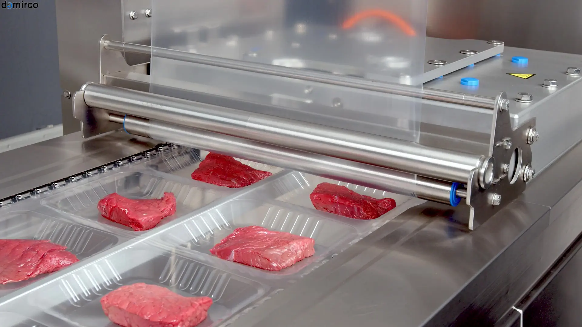 دستگاه اسکین پک صنعتی در حال بسته بندی گوشت قرمز بر روی سینی های مشکی