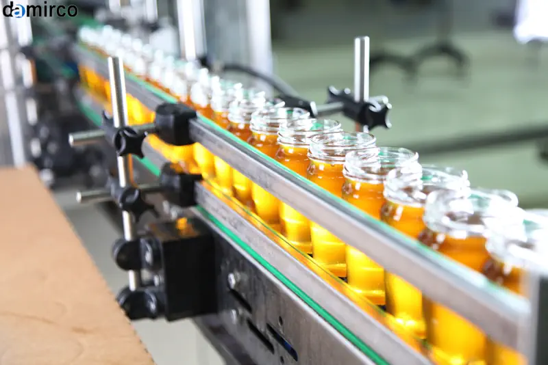 یک دستگاه درب بند اتوماتیک در حال بستن درب بطری‌های شیشه‌ای در یک خط تولید پیشرفته