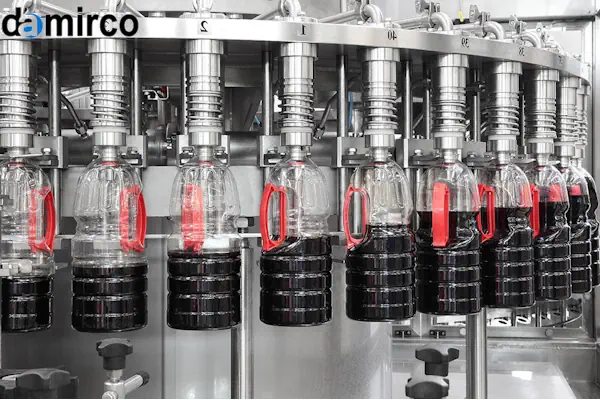 تصویر یک دستگاه پرکن مایعات صنعتی در یک کارخانه در حال پر کردن بطری‌ها