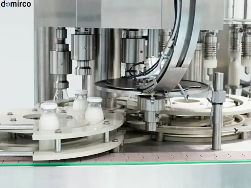 نمای نزدیک از هد یک دستگاه درب بند پیچی اتوماتیک در حال بستن درب یک بطری پلاستیکی