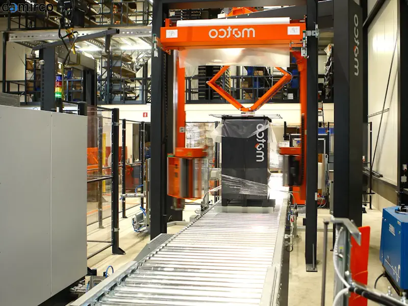 تصویر یک دستگاه استرچ پالت صنعتی در حال بسته‌بندی یک پالت بزرگ در یک کارخانه