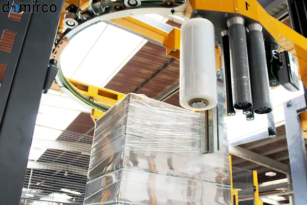 تکنسین متخصص در حال بازرسی و انجام تعمیر و نگهداری دستگاه استرج پالت صنعتی در یک کارخانه