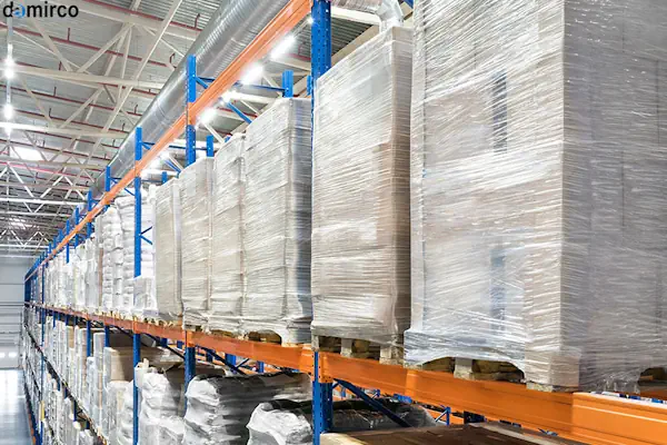 دستگاه استرچ پالت در حال بسته بندی یک پالت بزرگ در انبار صنعتی