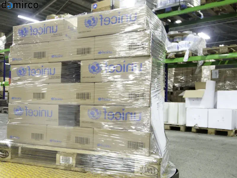 دستگاه استرچ پالت دروازه ای در حال بسته‌بندی یک پالت بزرگ و سنگین در یک محیط صنعتی