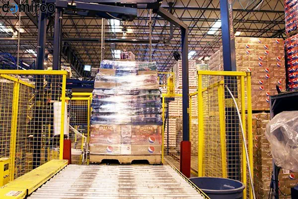 یک دستگاه استرچ پالت دست دوم در محیط کارخانه در حال بسته‌بندی یک پالت بزرگ با نایلون استرج