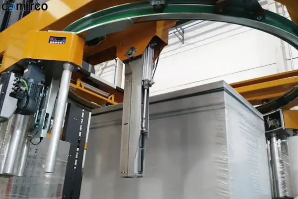 تصویری از انواع دستگاه استرچ پالت شامل مدل صفحه گردان و بازویی در یک انبار صنعتی