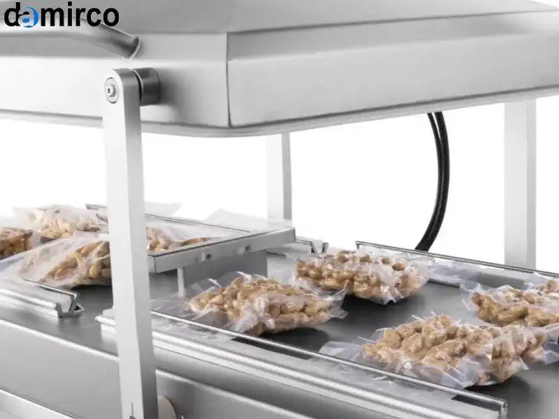 یک دستگاه بسته بندی وکیوم دو کابین صنعتی از جنس استیل ضد زنگ در یک کارخانه تولیدی