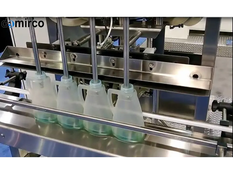 تصویر یک دستگاه پرکن مایعات دستی از جنس استیل ضد زنگ که در یک کارگاه کوچک برای پر کردن بطری‌های شیشه‌ای استفاده می‌شود.