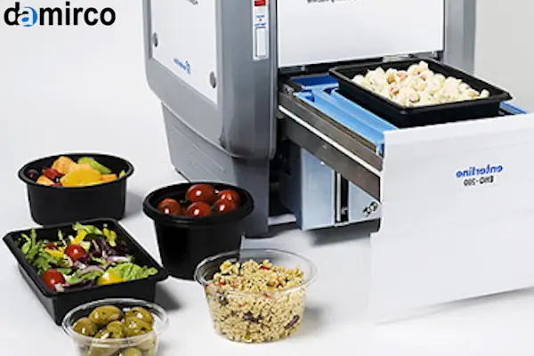 یک دستگاه سیل حرارتی صنعتی در حال بسته بندی ظروف پلاستیکی مواد غذایی