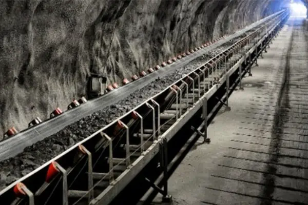 تصویر یک سیستم نوار نقاله معدنی بزرگ که در یک معدن روباز در حال جابجایی سنگ‌های استخراج شده است.