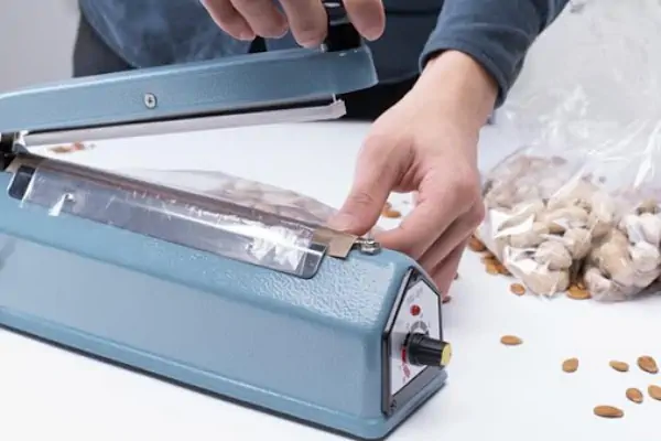 یک دستگاه دوخت پلاستیک دست دوم در یک کارگاه صنعتی در حال کار