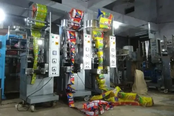 یک تکنسین در حال انجام سرویس و نگهداری بر روی یک دستگاه بسته بندی توزین دار صنعتی پیشرفته