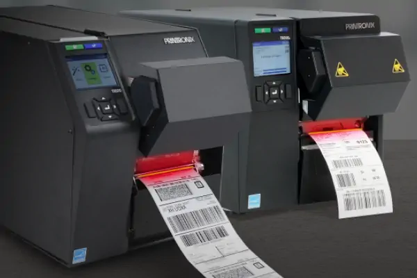 اپراتور انبار در حال استفاده از لیبل پرینتر صنعتی برای چاپ بارکد و برچسب‌گذاری کالاها جهت مدیریت موجودی