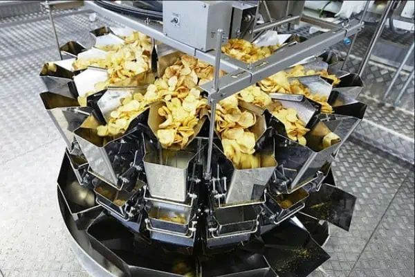 دستگاه بسته بندی توزین دار چیپس و پفک در حال پر کردن بسته‌های اسنک با دقت بالا