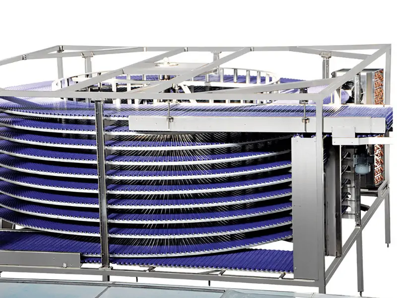 نمای داخلی یک تونل سرد کن اسپیرال صنعتی با تسمه نقاله در حال حرکت محصولات