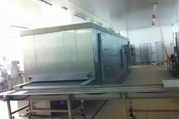 یک خط تولید صنعتی با تونل سرد کن کیک و کلوچه که محصولات را به سرعت خنک می‌کند.