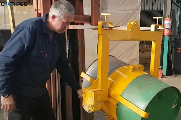 دستگاه بشکه گردان صنعتی در حال چرخاندن یک بشکه آبی رنگ در یک کارخانه داروسازی