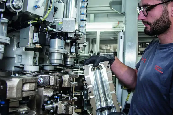 یک دستگاه بادکن پت کوچک نیمه اتوماتیک در حال تولید بطری‌های شفاف پلاستیکی