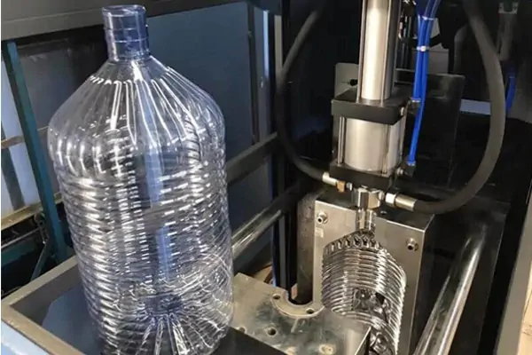دستگاه بادکن پت تمام اتوماتیک در حال تولید بطری‌های شفاف پلاستیکی