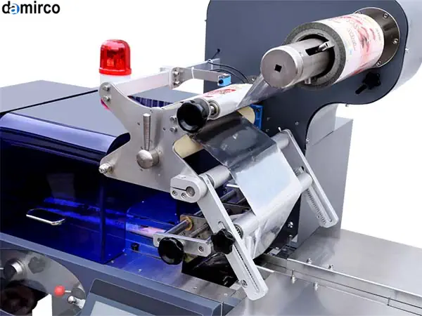 دستگاه بسته بندی پیلو پک افقی در حال بسته بندی محصولات غذایی