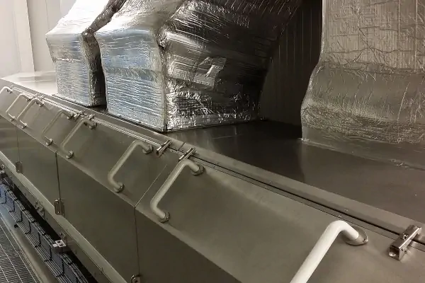 یک تکنسین متخصص در حال انجام عملیات تعمیر و نگهداری تونل سرد کن صنعتی در یک کارخانه