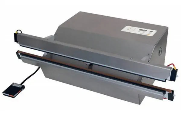 نمای نزدیک از یک دستگاه وکیوم دوخت پلاستیک صنعتی در حال بسته‌بندی یک محصول غذایی.