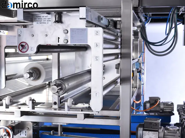 نمای نزدیک از دستگاه پیلو پک در حال بسته بندی تک عددی بیسکویت