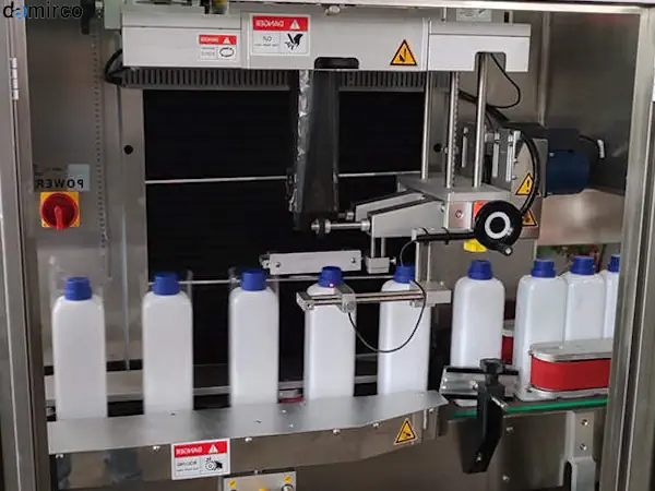 تکنسین در حال انجام عیب یابی و تعمیرات رایج دستگاه لیبل شیرینگ در یک کارخانه صنعتی