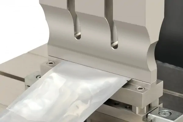 نمای نزدیک از هورن و چرخ سندان دستگاه دوخت التراسونیک در حال اتصال دو لایه پارچه بی‌بافت