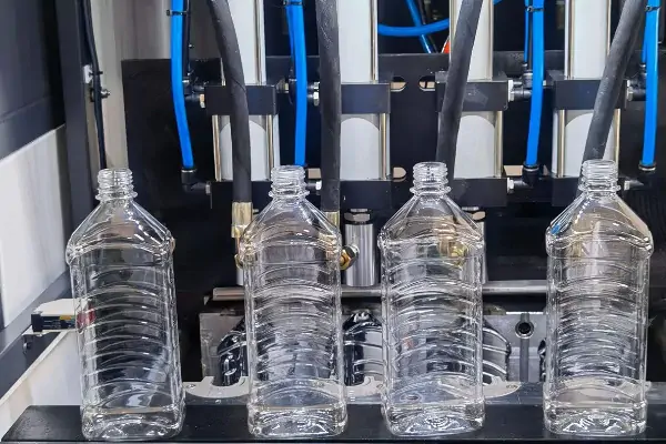 دستگاه بادکن پت اتوماتیک در حال تولید بطری‌های پلاستیکی شفاف