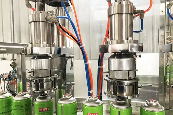 نمای نزدیک از دستگاه اسپری پرکن نیمه اتوماتیک در حال پر کردن قوطی اسپری