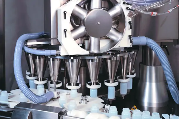 یک دستگاه پرکن پودری دست دوم در حال بسته‌بندی ادویه در یک کارگاه تولیدی