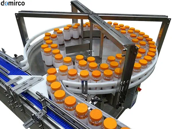 نمای نزدیک از یک میز ترافیک انباشت گردان در حال کار در یک خط تولید بطری