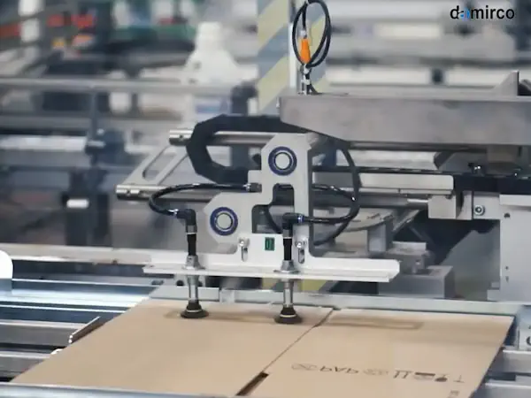 تعمیرکار در حال تنظیم و سرویس یک دستگاه چسب زن کارتن صنعتی در کارخانه