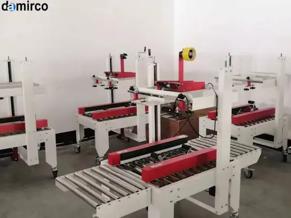 تصویر یک دستگاه چسب زن کارتن صنعتی در حال کار در یک خط تولید