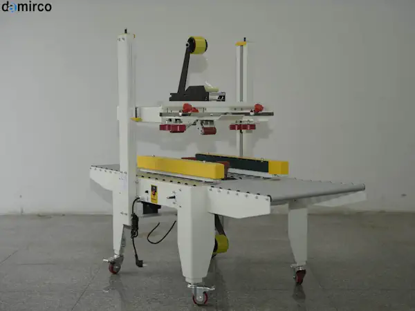 یک دستگاه چسب زن کارتن نیمه اتوماتیک آبی رنگ در یک محیط کارگاهی