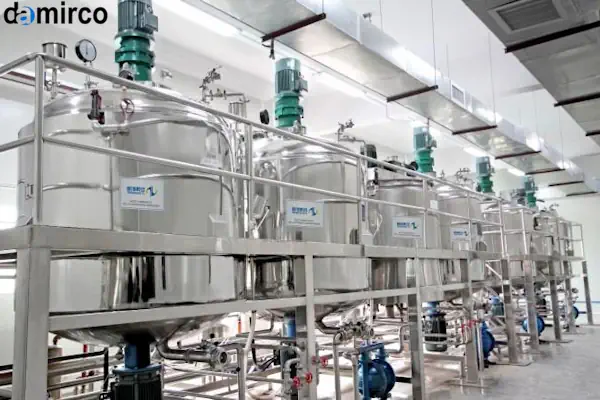 یک میکسر مایعات صنعتی بزرگ از جنس استیل ضدزنگ با موتور و گیربکس در یک کارخانه تمیز