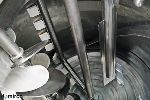 کارشناس فنی در حال انجام تعمیر و نگهداری یک میکسر مایعات صنعتی در محیط کارخانه