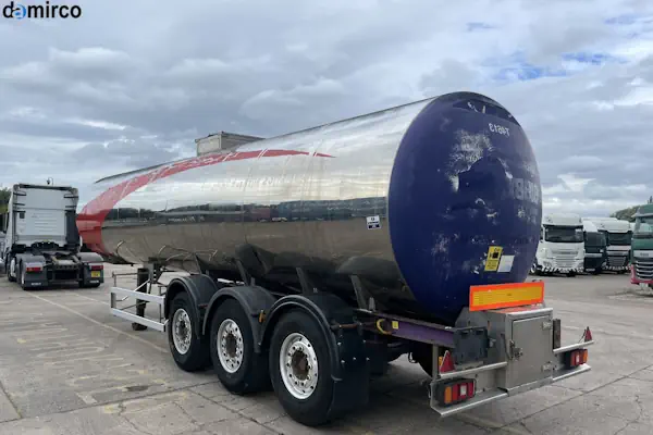 تصویر یک تانکر حمل لبنیات از جنس استیل ضدزنگ در حال بارگیری شیر خام از یک واحد دامداری