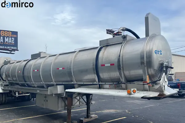 نمای دقیق از اجزای تانکر حمل شیر شامل شیرآلات و منهول روی بدنه فولادی