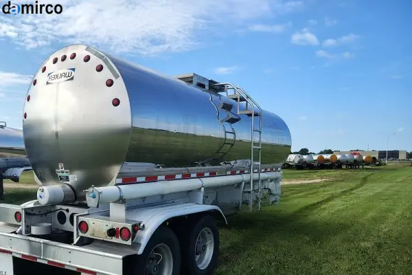 نمای نزدیک از یک مخزن استیل حمل شیر درخشان که روی یک کامیون نصب شده است.