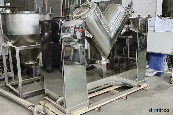 نمای نزدیک از یک میکسر پودر استیل صنعتی در حال ترکیب مواد پودری