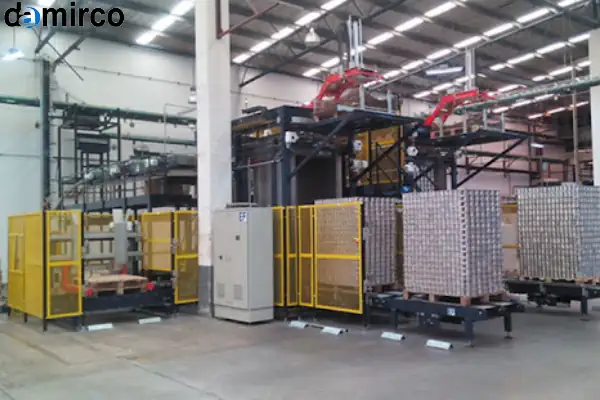 دستگاه دی پالتایزر رباتیک در حال جابجایی کارتن‌ها از روی پالت در یک کارخانه مدرن